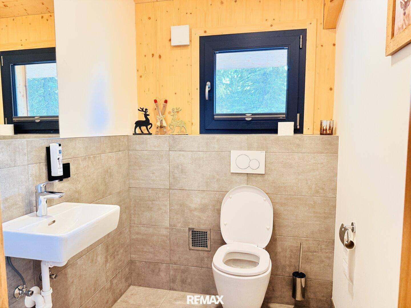 Kleines Gäste-WC mit Fenster, Wand-WC und modernem Waschbecken.