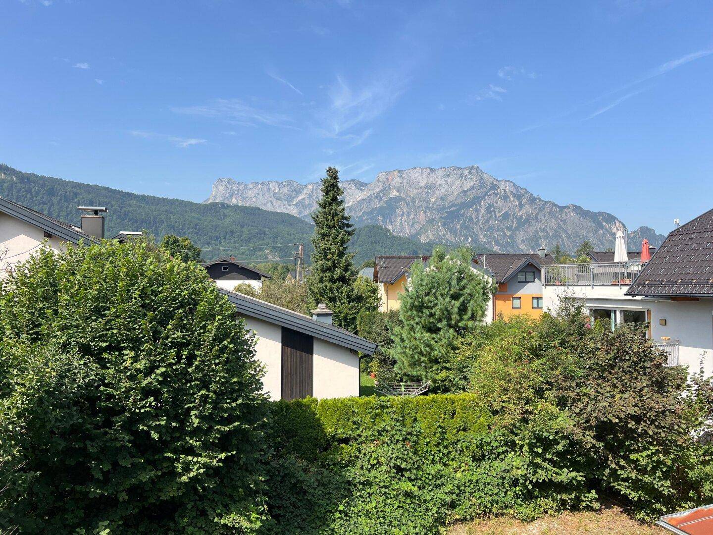 Weitläufiger Blick auf die umliegende Berglandschaft und Nachbarhäuser an einem klaren Tag.