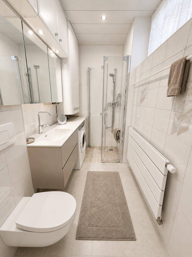 Modernes Badezimmer mit Dusche, Waschmaschine und wandhängendem WC.