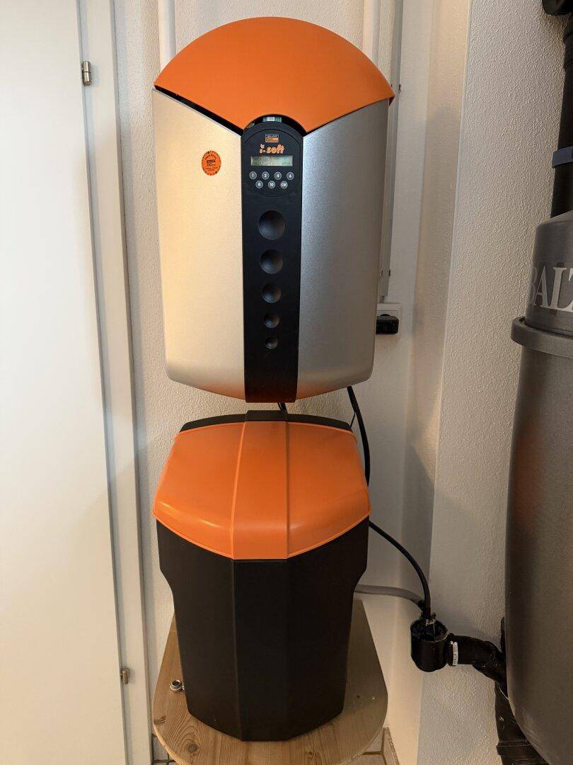 Kompakte Wasserenthärtungsanlage mit digitaler Anzeige in einem Technik- oder Hauswirtschaftsraum.