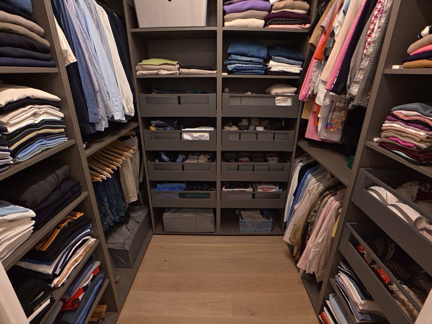 Geräumiger begehbarer Kleiderschrank mit vielen Regalen und Schubladen für Kleidung.
