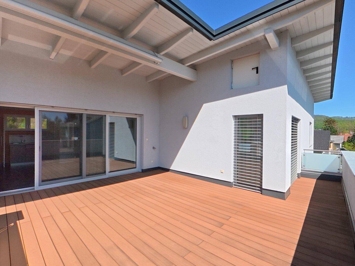 Weitläufige Dachterrasse mit Holzboden und viel Platz für Outdoor-Möbel und Entspannung.