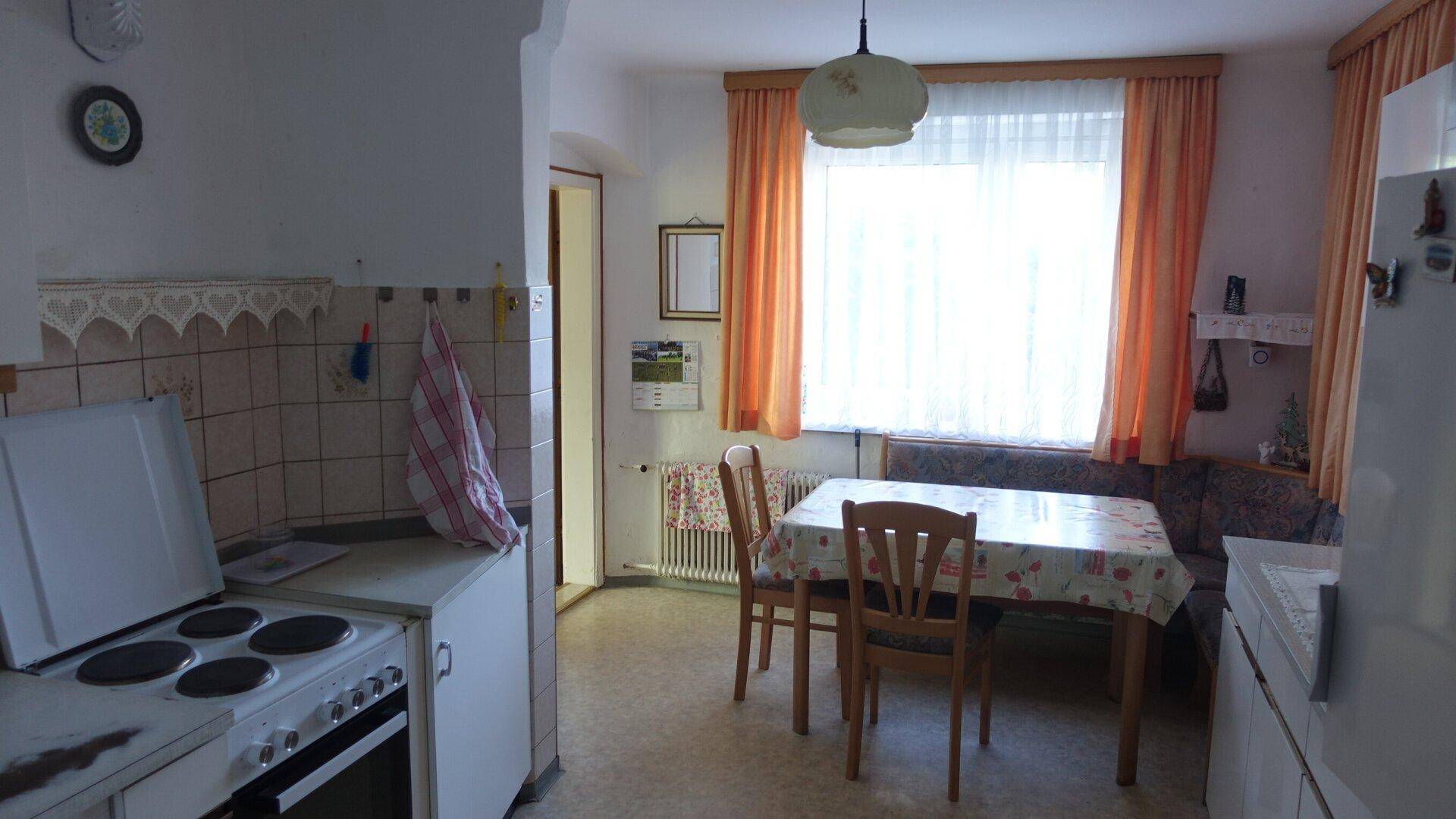 Funktionale Küche mit Essbereich, Herd und Fenster, im traditionellen Stil gehalten.