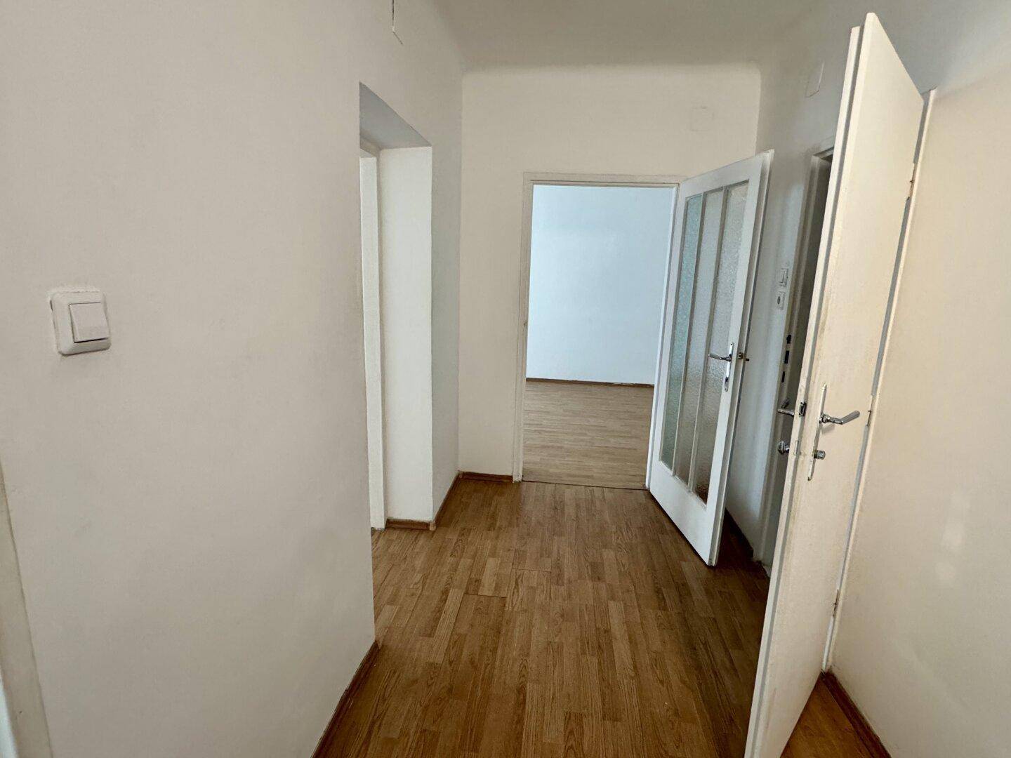 Heller Flur mit Laminatboden und Türen zu den angrenzenden Räumen.