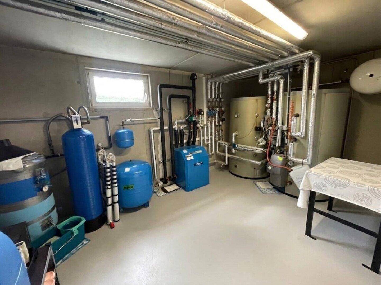 Gut ausgestatteter Technikraum mit moderner Heizungsanlage und Warmwasserspeichern.