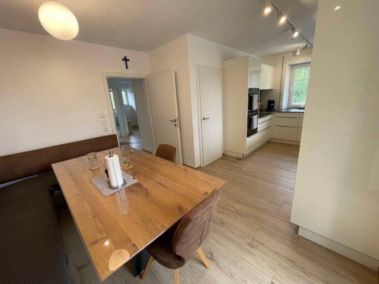 Geräumiger Essbereich mit Holztisch und Blick in die moderne Küche.