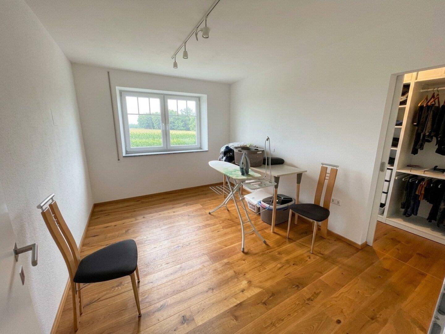 Praktischer Raum mit Bügelbrett und angrenzendem begehbarem Kleiderschrank.