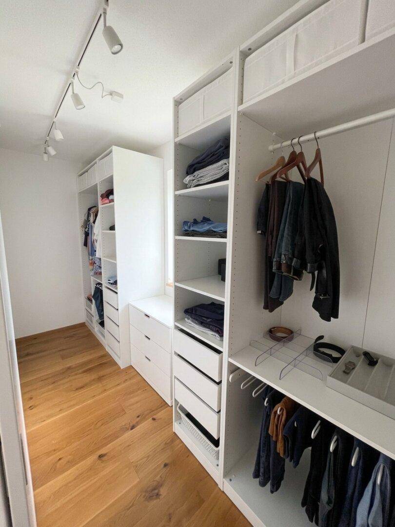 Geräumiger begehbarer Kleiderschrank mit vielen Regalen und Hängemöglichkeiten.