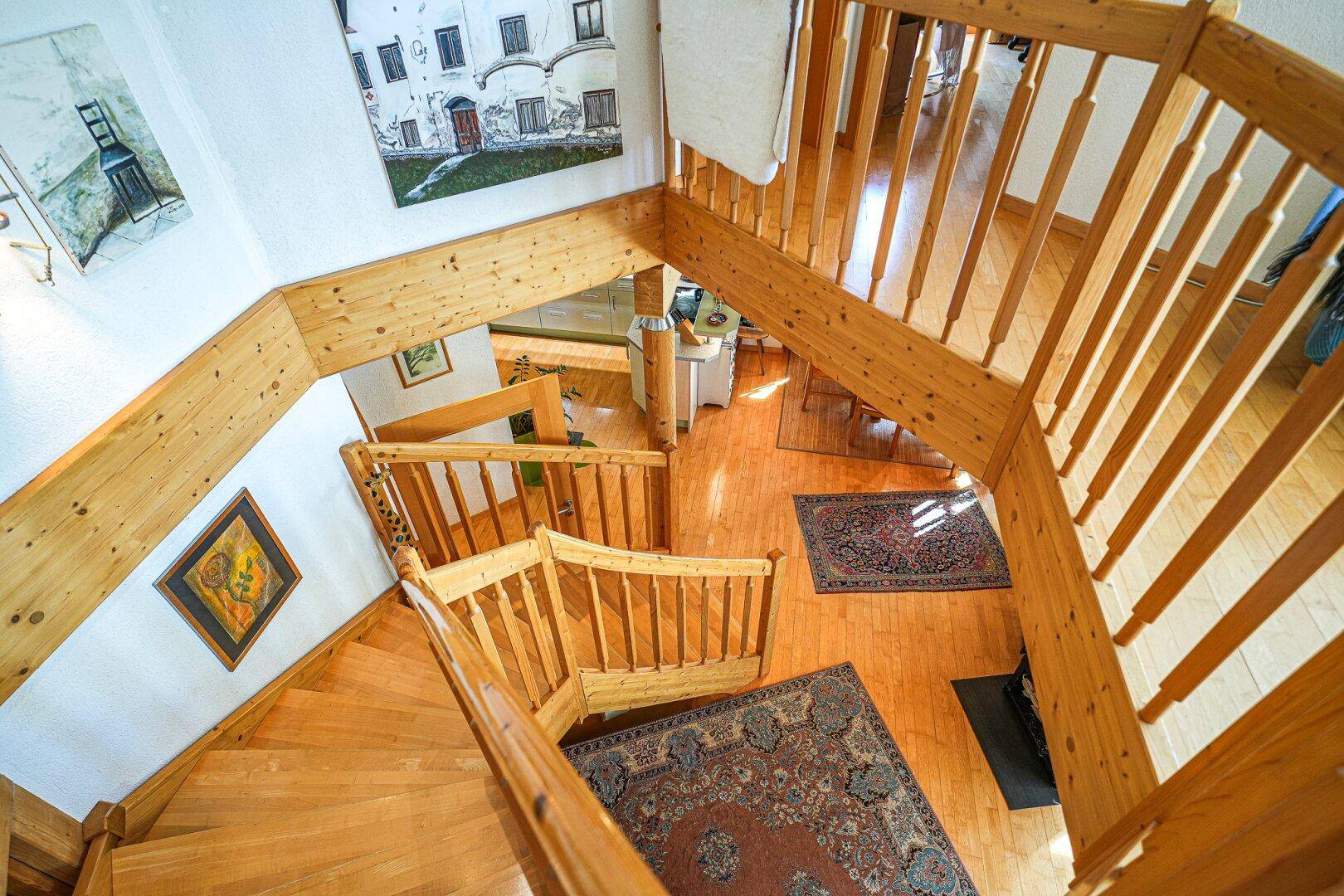 Holztreppe aus der Vogelperspektive, die verschiedene Ebenen des Hauses verbindet.