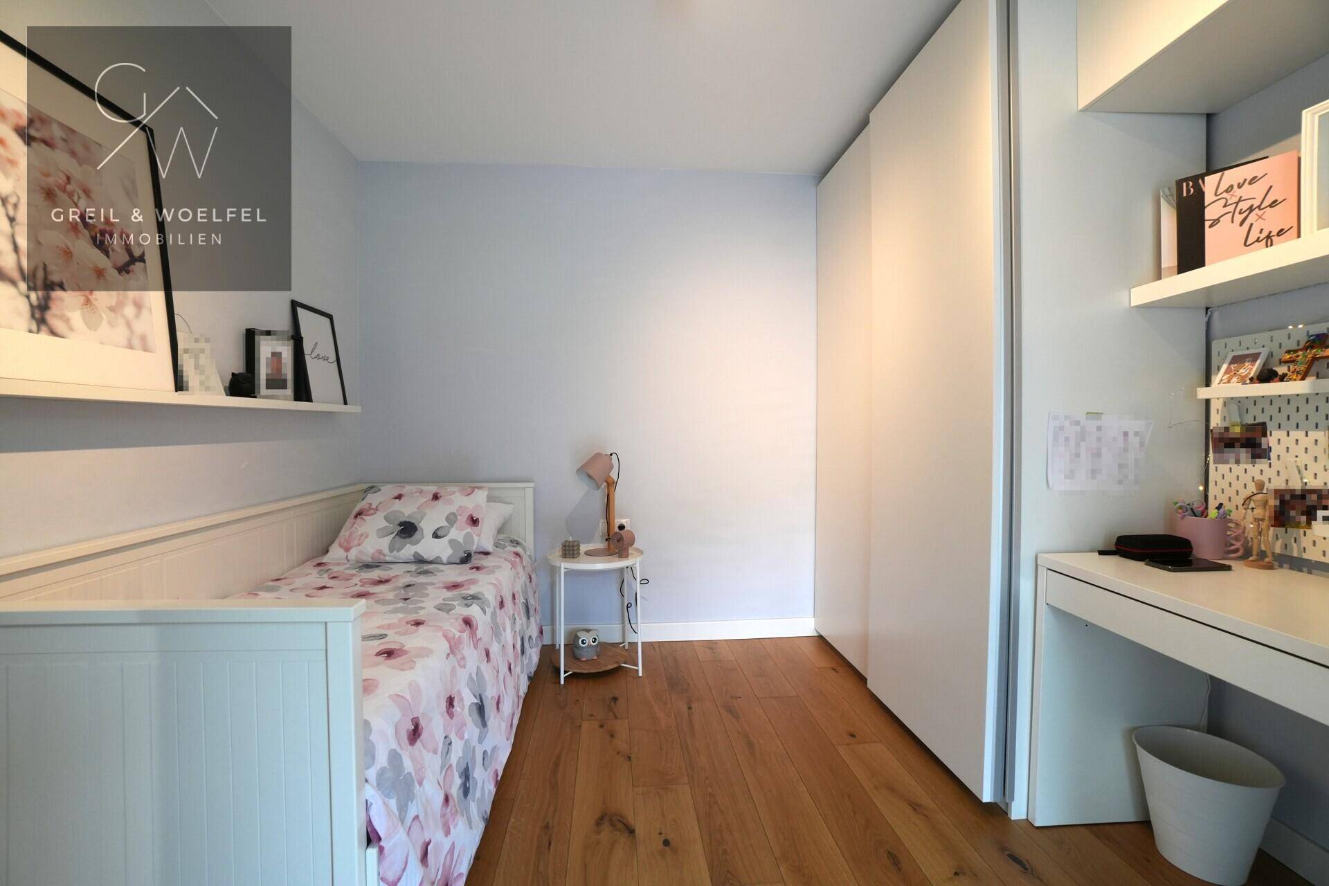 Freundliches Kinderzimmer mit Holzboden, Einzelbett und praktischen Wandregalen.