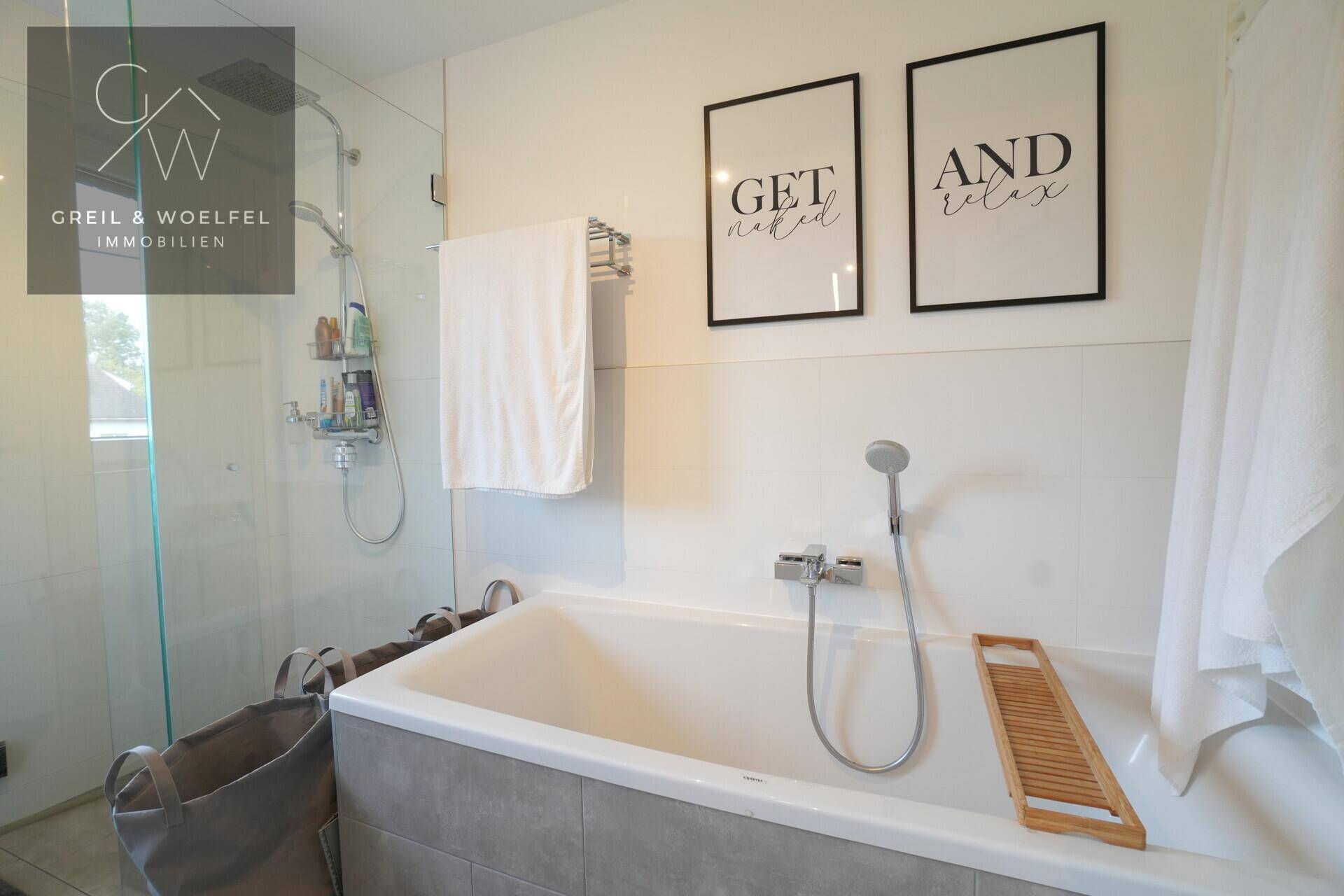 Helles Badezimmer mit Badewanne und separater Duschkabine, ideal für Entspannung.