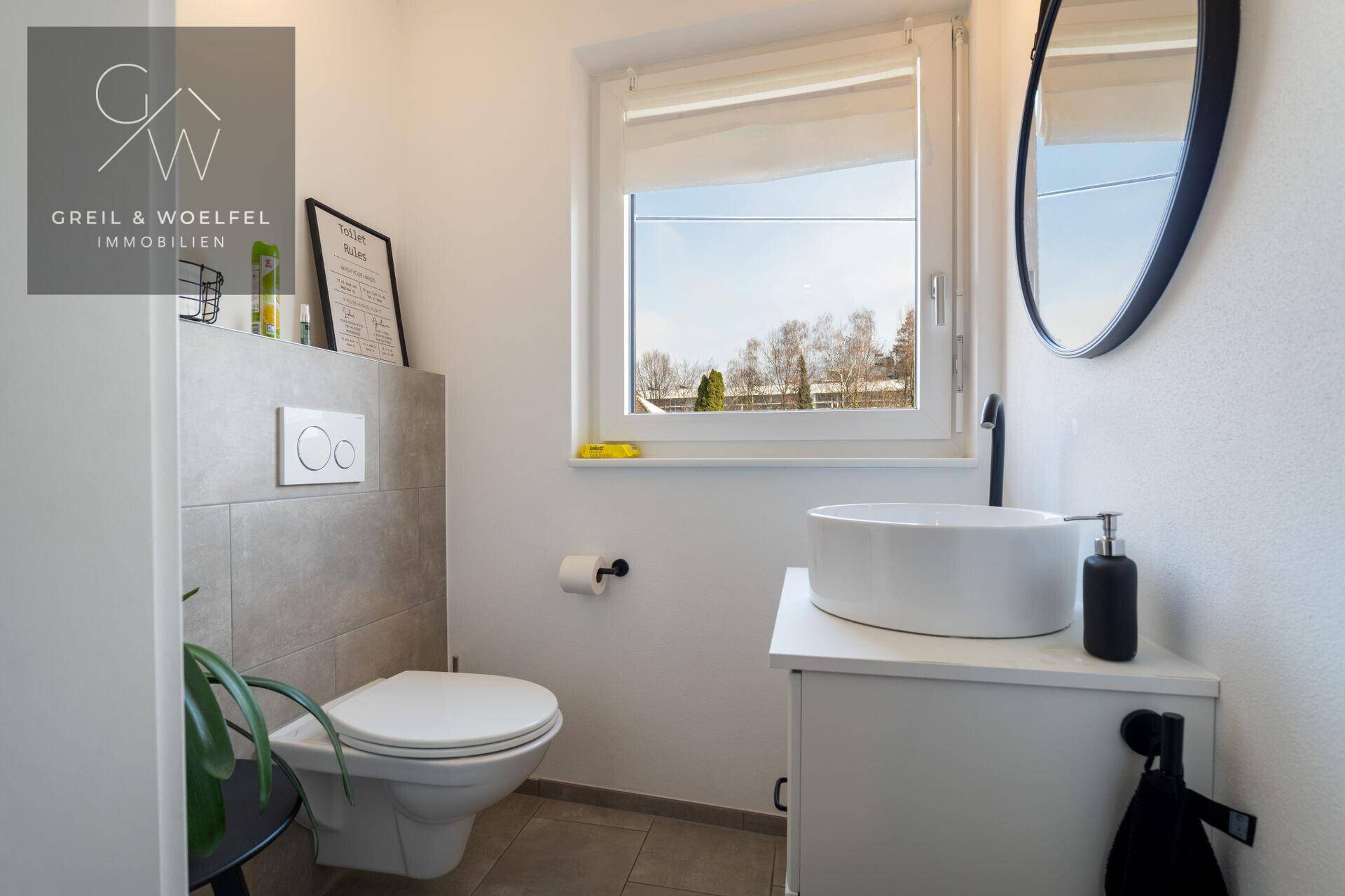 Modernes Gäste-WC mit Fenster, wandhängendem WC und stilvollem Aufsatzwaschbecken.