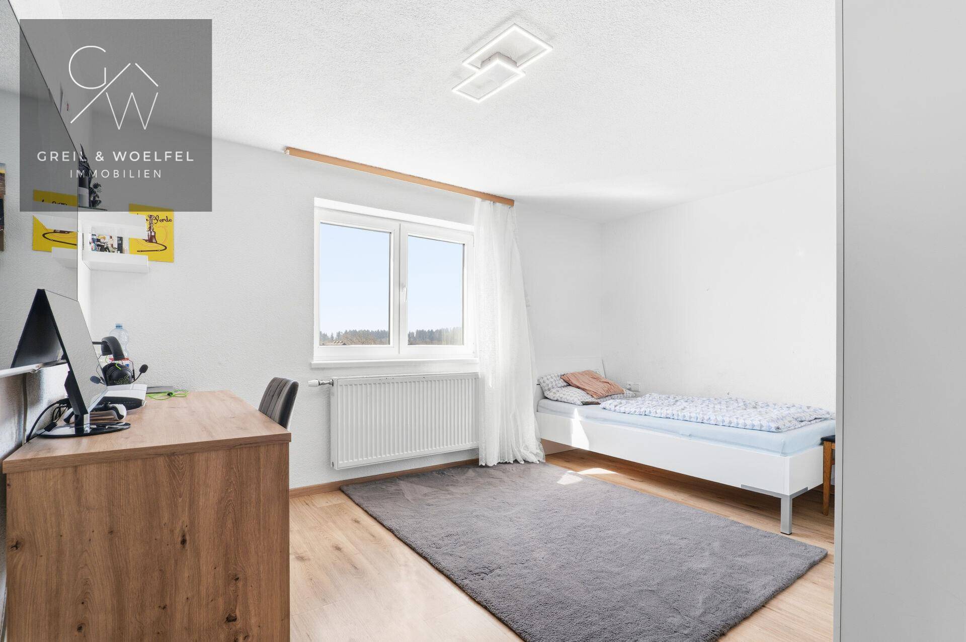 Kinderzimmer oder Gästezimmer mit Einzelbett, Schreibtisch und hellem Fenster, ideal zum Lernen und Schlafen.