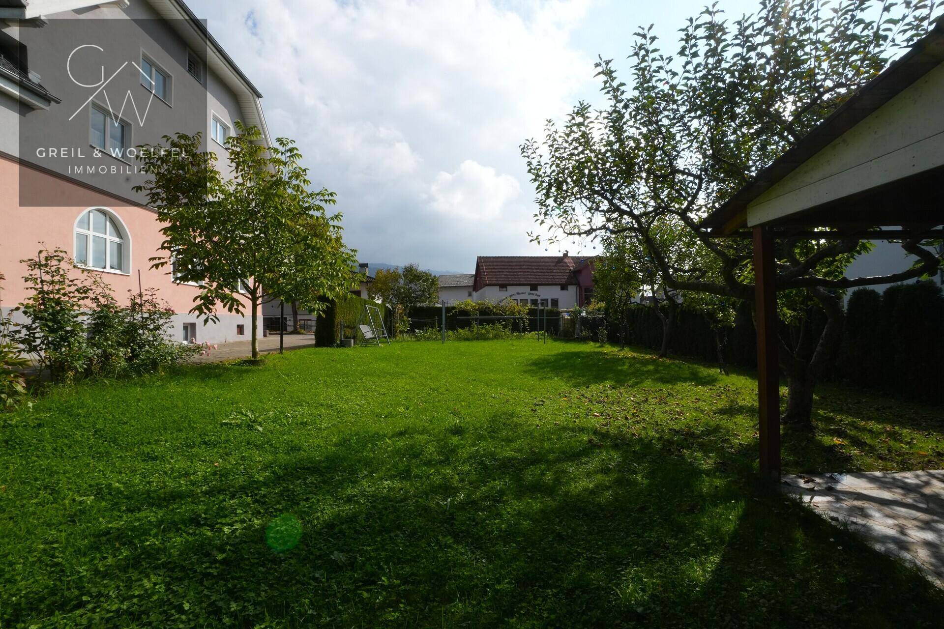 Großer, gepflegter Garten mit Rasenfläche und Bäumen, ideal für Erholung im Freien.