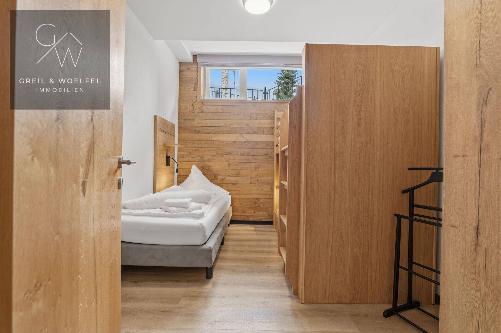 Kinderzimmer mit Einzelbett, Etagenbetten und Holzakzenten, ideal für Gäste.