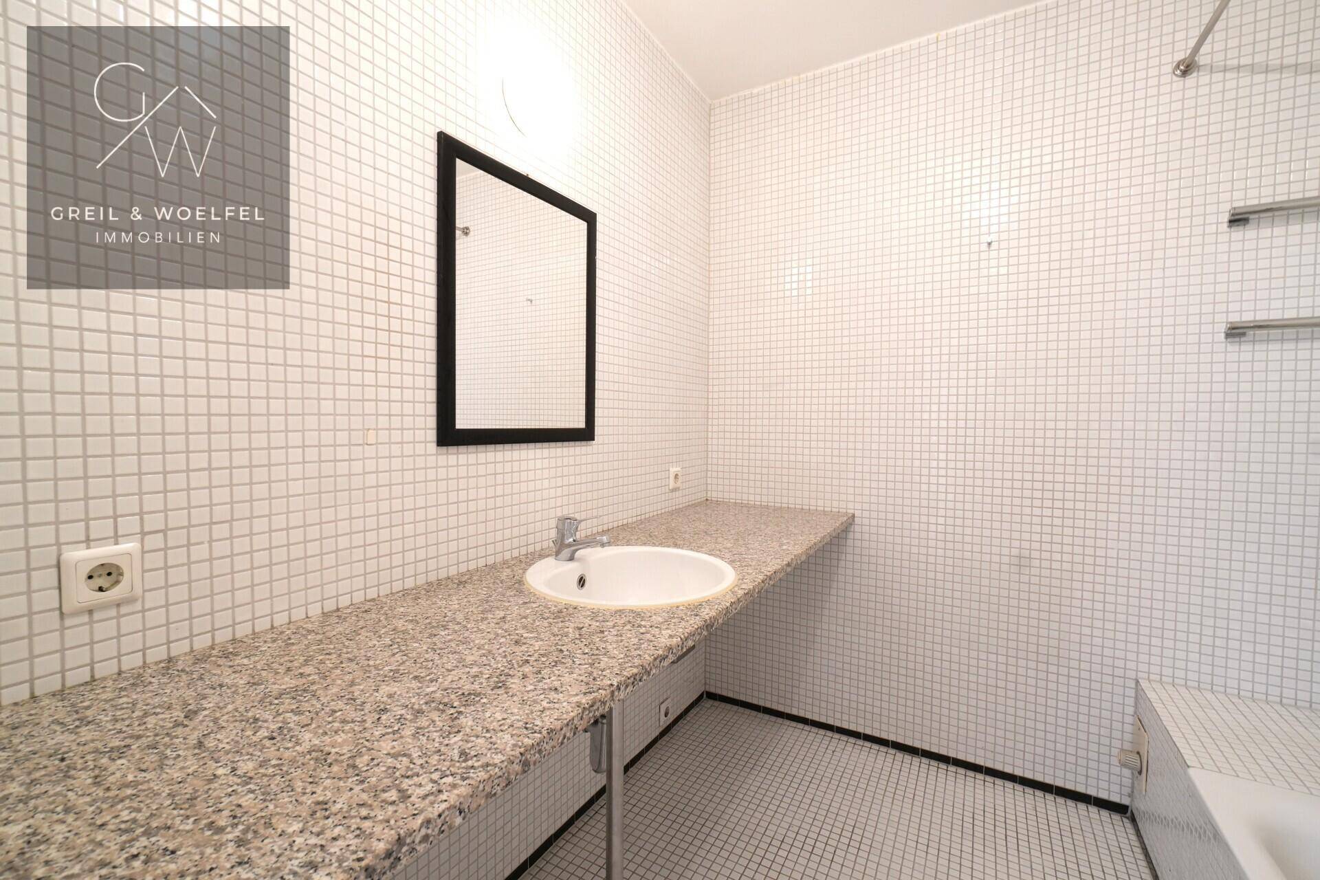 Badezimmer mit kleinen weißen Fliesen, Einzelwaschbecken und Granit-Arbeitsplatte.
