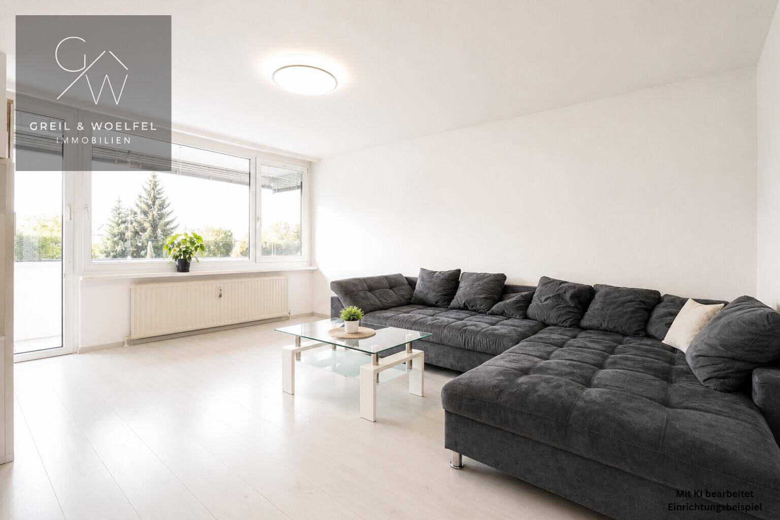 Geräumiges Wohnzimmer mit großem Ecksofa, Couchtisch und Zugang zum verglasten Balkon.