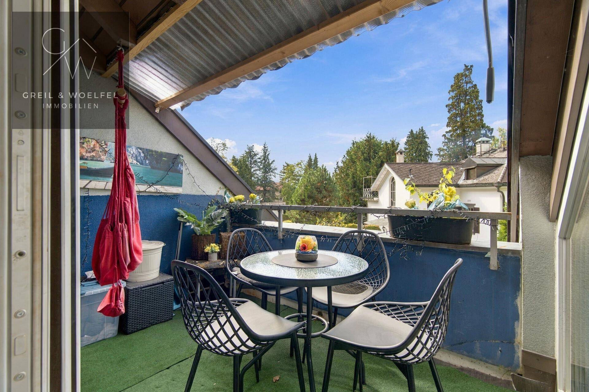 Überdachter Balkon mit Sitzgelegenheiten und Blick ins Grüne, ideal für entspannte Stunden.