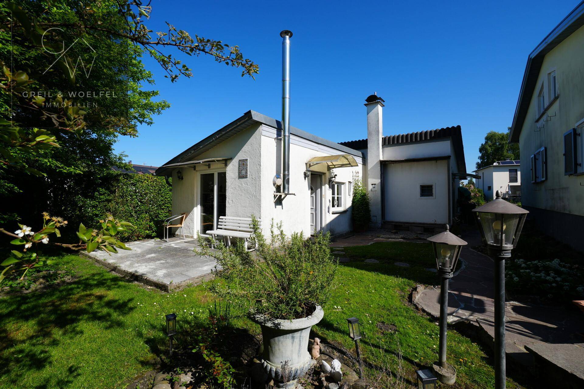 Rückseite des Hauses mit gepflegtem Garten, kleiner Terrasse und viel Grünfläche zum Entspannen.