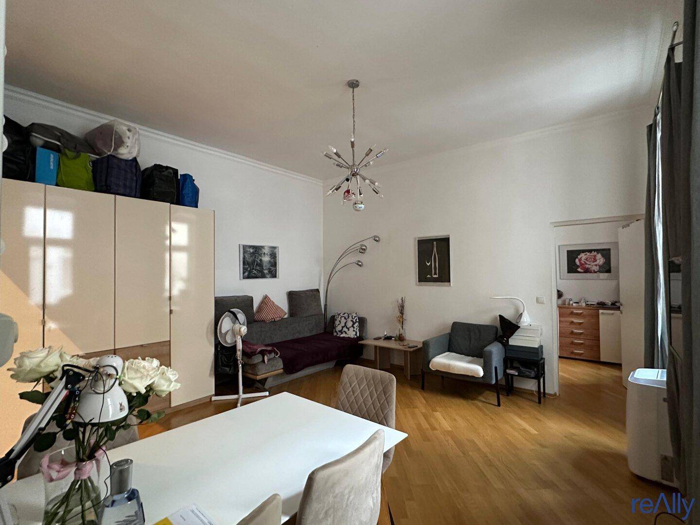 Heller Wohnbereich mit Esstisch, Sofa und Schränken.