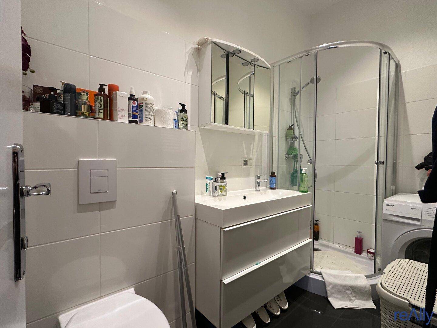 Modernes Badezimmer mit Duschkabine, Waschbecken und Spiegelschrank.