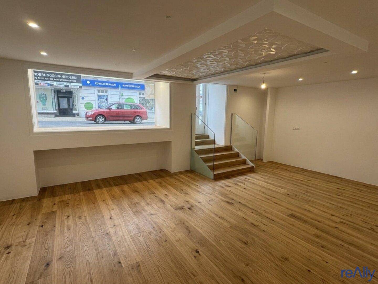 Geräumiger, heller Ladenbereich mit Holzboden, moderner Decke und Blick auf die Straße.