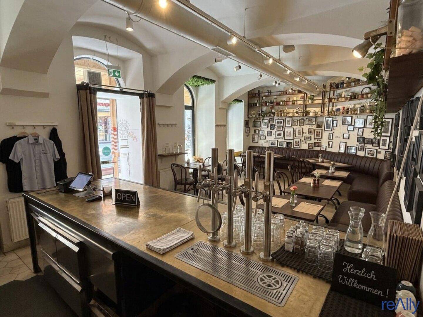 Blick auf den Eingangsbereich und die Bar eines Restaurants mit Zapfanlage und gemütlichen Sitzgelegenheiten.