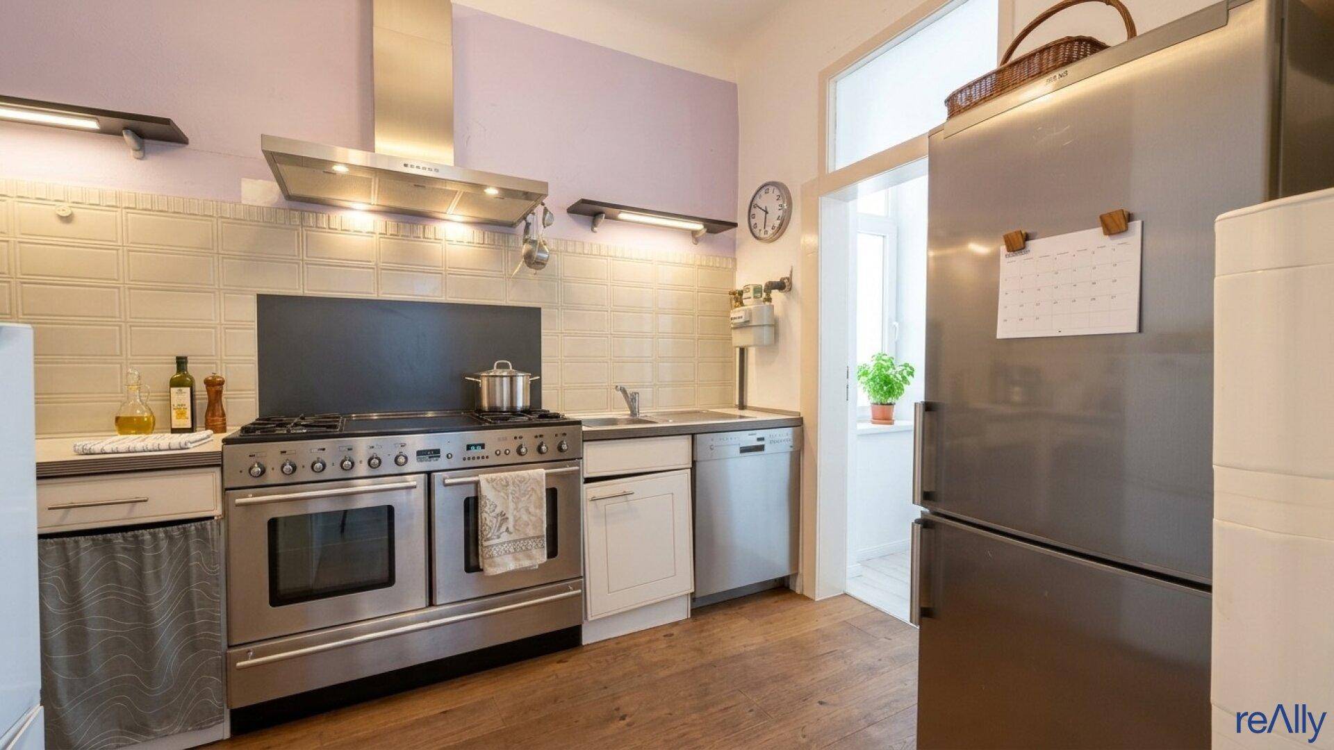 Funktionale Küche mit Edelstahlgeräten, Spülmaschine und großem Kühlschrank.