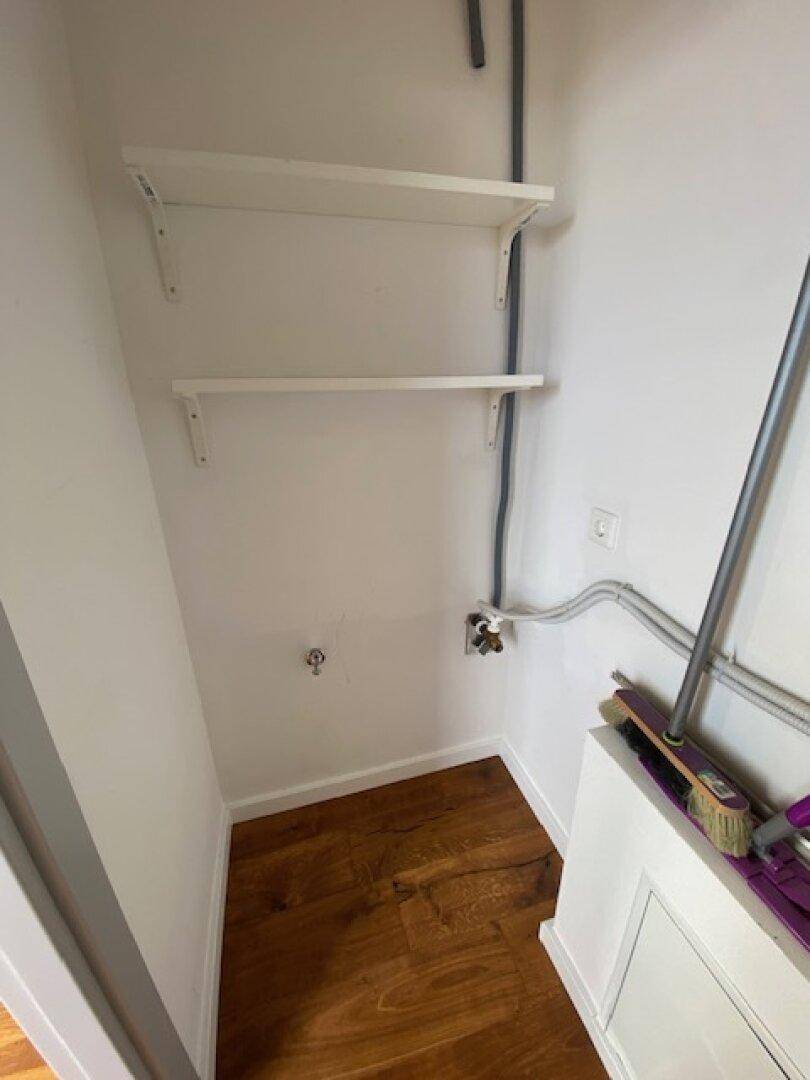 Kleiner Abstellraum mit praktischen Regalen und Holzboden für zusätzlichen Stauraum im Haushalt.