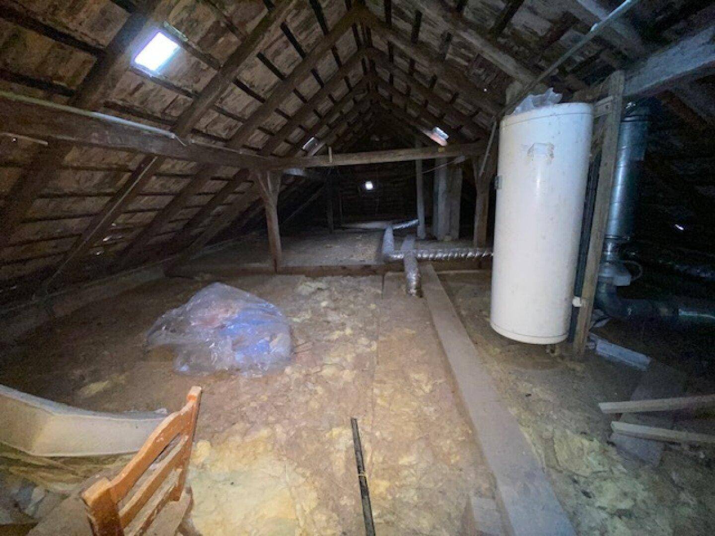 Unausgebauter Dachboden mit sichtbarer Holzkonstruktion und Isolierung, bietet Ausbaupotenzial.