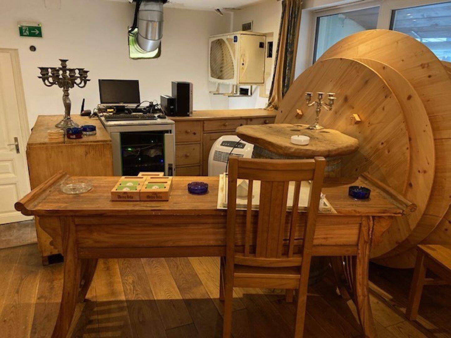 Bürobereich mit Holzschreibtischen, Computer und dekorativen großen Holzspulen.