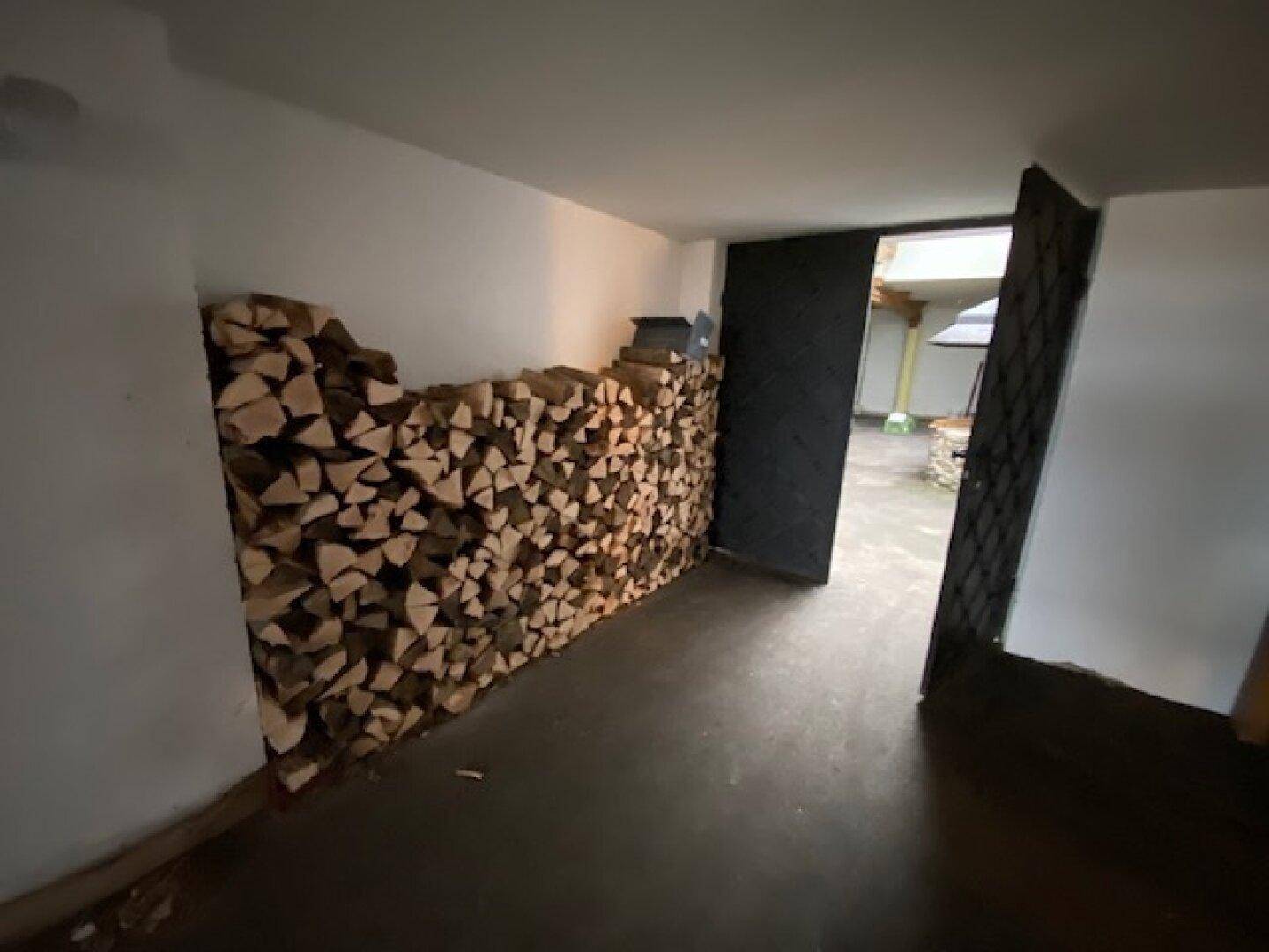 Lagerraum mit gestapeltem Brennholz, bereit für den Kamin oder Ofen.