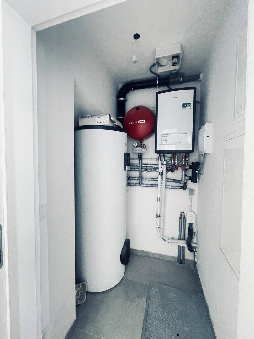 Technikraum mit Warmwasserspeicher und Heizungsanlage.