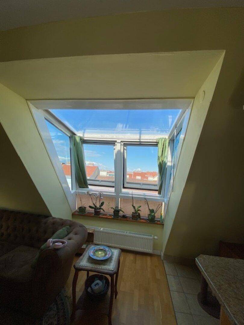 Helles Wohnzimmer mit einer großen Fensterfront, die viel Tageslicht hereinlässt und einen weiten Blick bietet.