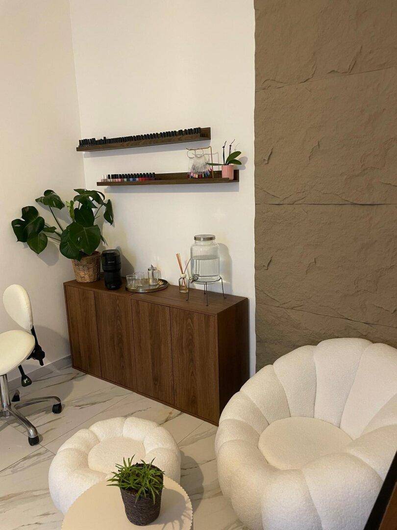 Gemütlicher Bereich mit Holzschrank, dekorativen Regalen und einem bequemen weißen Sessel.