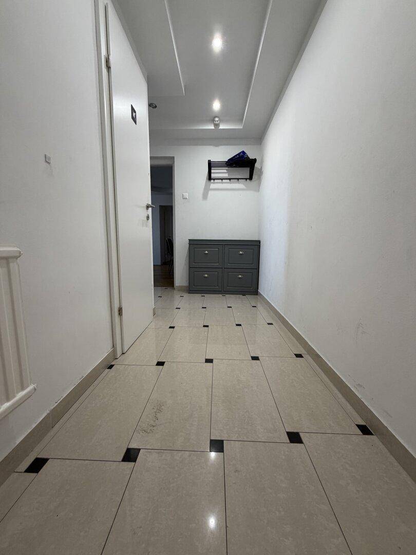 Langer Flur mit modernen Fliesen, praktischem Schuhschrank und Garderobe für den Eingangsbereich.