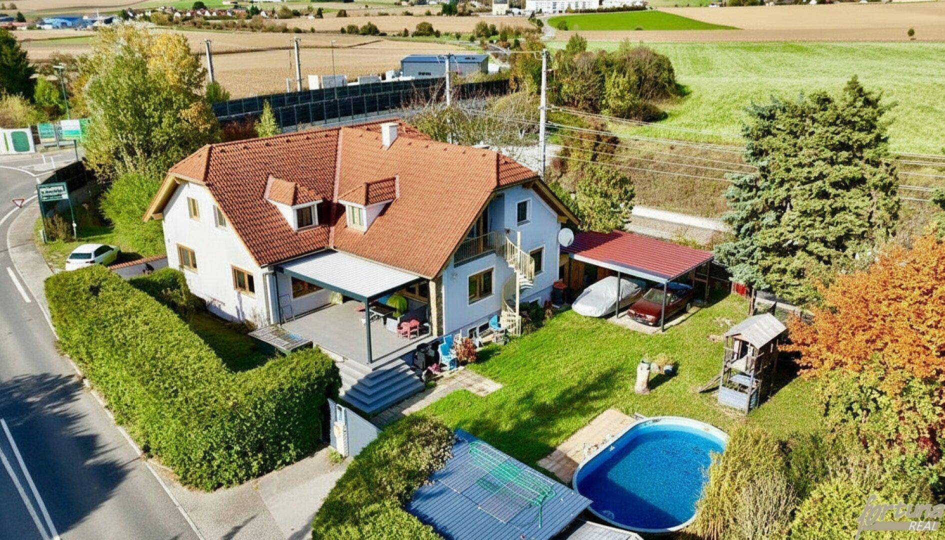 Luftaufnahme des Einfamilienhauses mit Garten, Pool und ländlicher Umgebung.