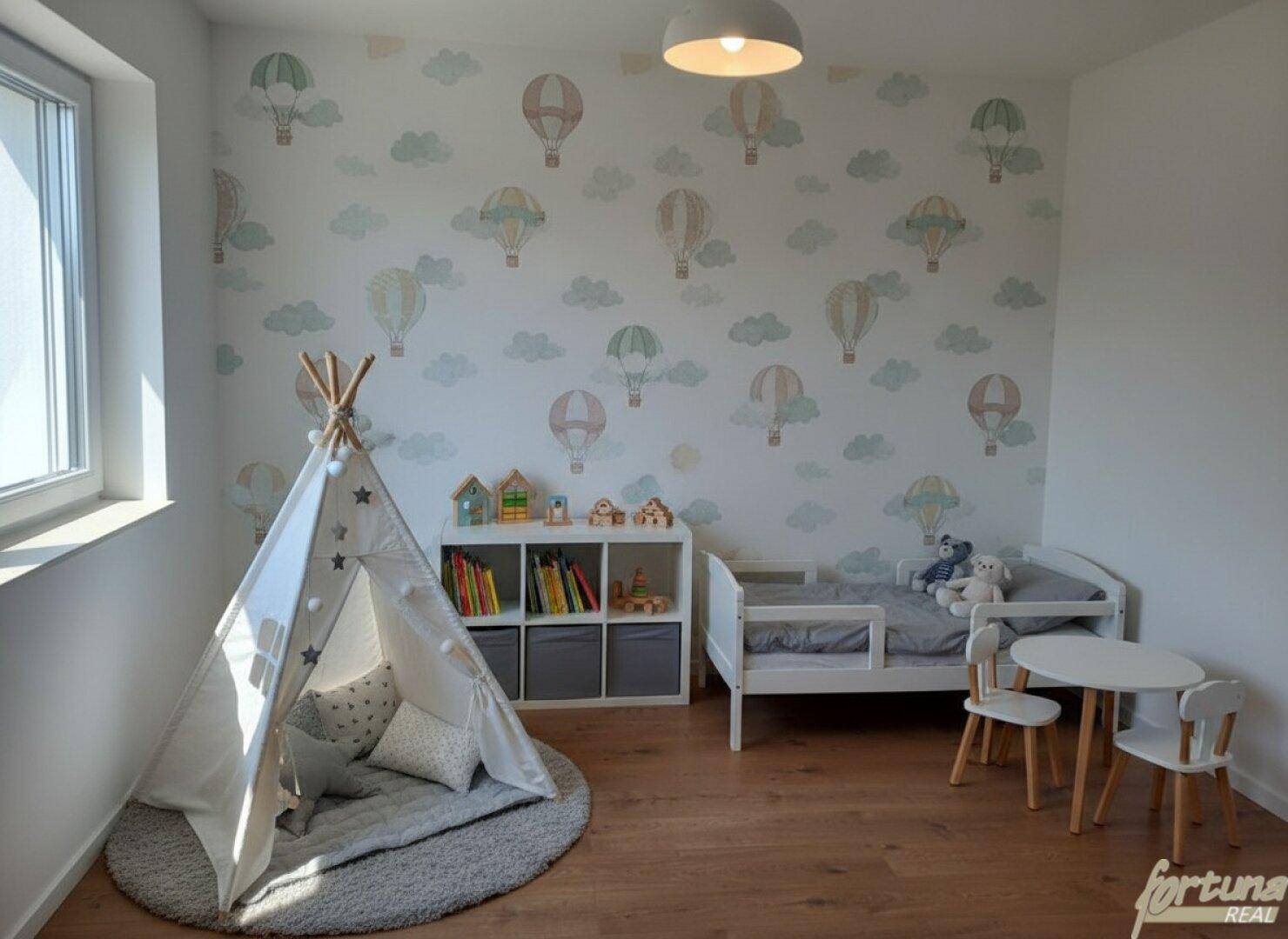 Helles Kinderzimmer mit verspielter Tapete, Holzboden und gemütlichem Tipi-Zelt.