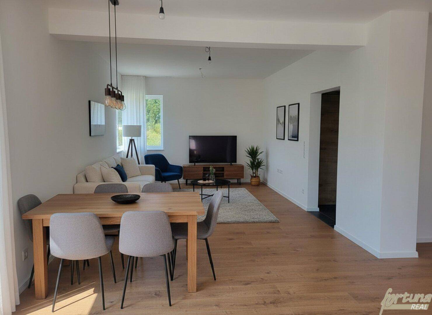 Geräumiger Wohn-Essbereich mit Holzboden, modernem Esstisch und gemütlicher Sitzecke.