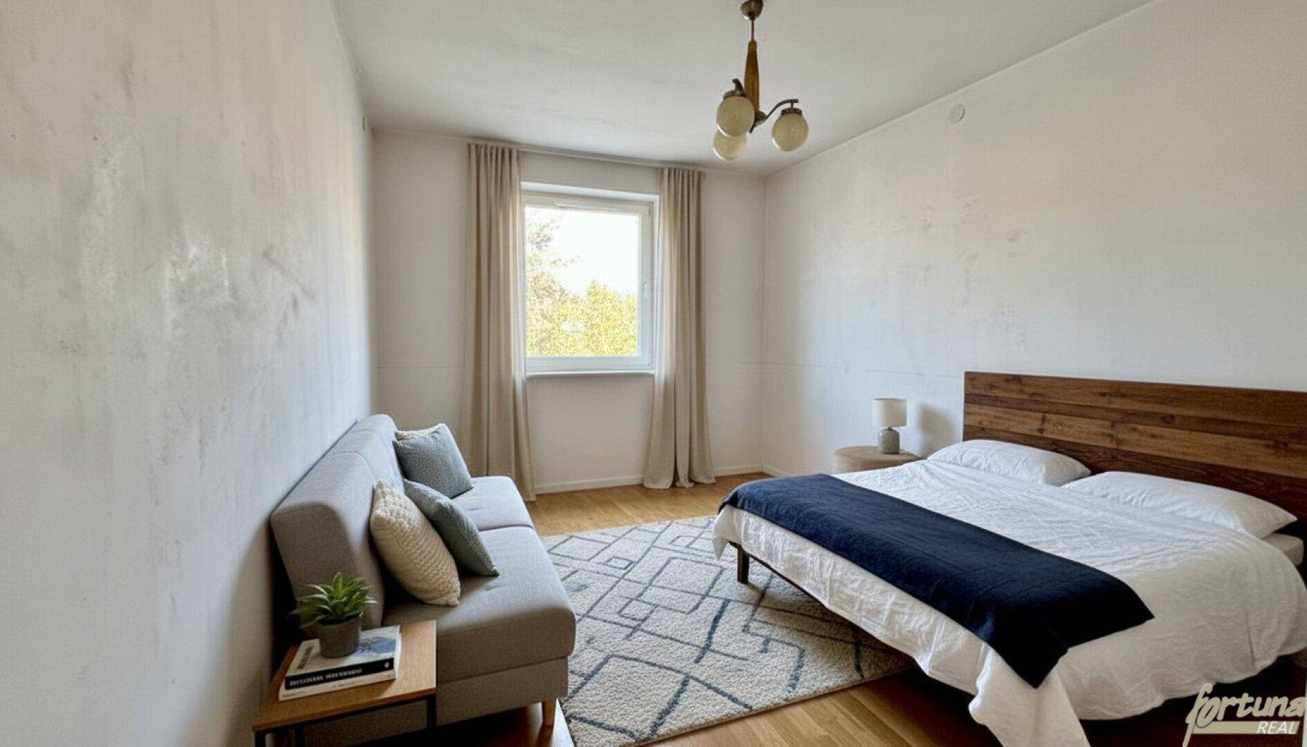 Geräumiges Schlafzimmer mit Doppelbett, Sofa und Holzboden, gut beleuchtet durch ein Fenster.