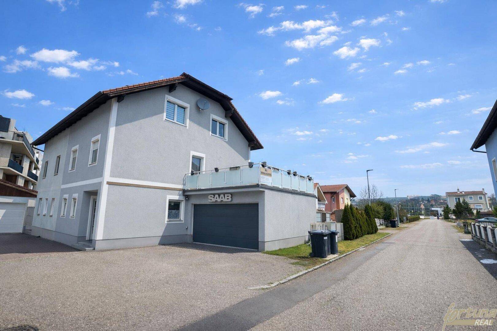 Ansicht des Hauses von der Straße mit Garage und Einfahrt.
