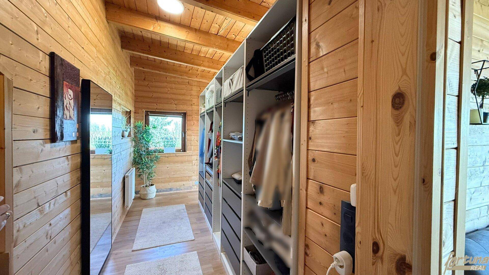 Praktischer begehbarer Kleiderschrank mit viel Stauraum und Holzwänden.