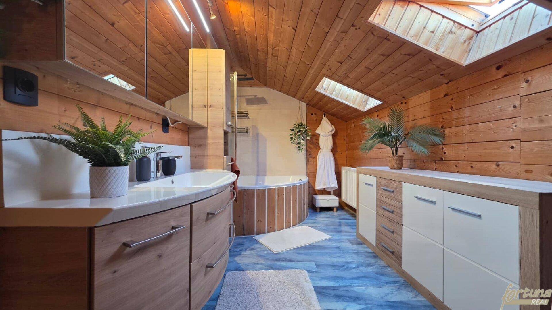Modernes Badezimmer mit Holzwänden, blauen Fliesen, Dachfenstern und Whirlpool.