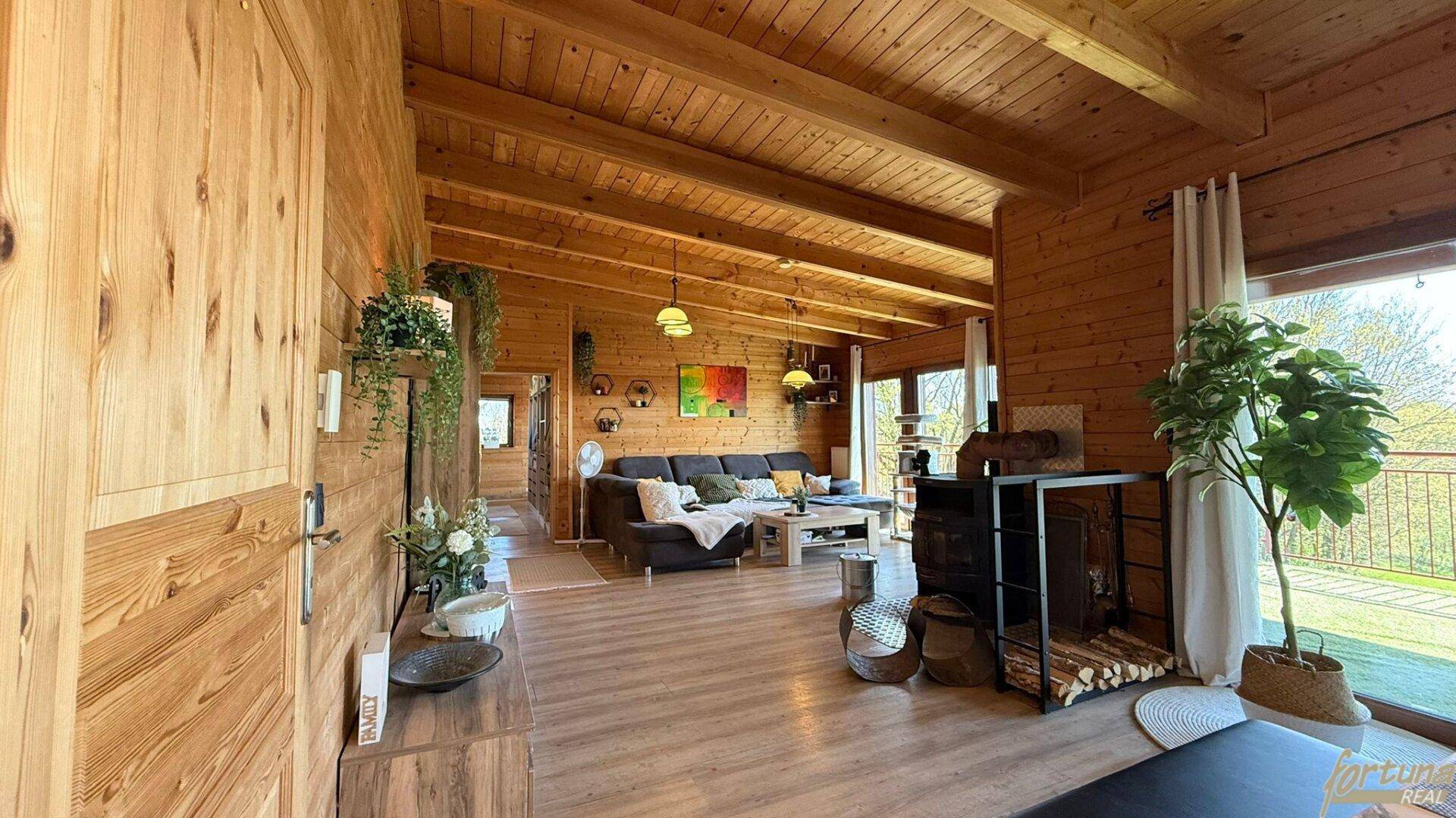 Geräumiger Eingangsbereich mit Holzwänden und Blick in den offenen Wohnbereich.