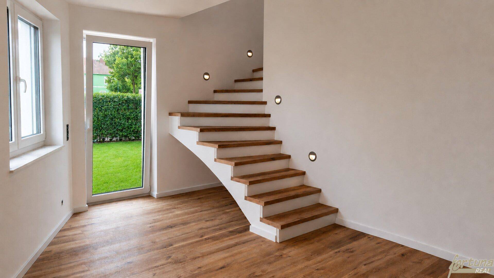 Heller Eingangsbereich mit moderner Holztreppe und direktem Zugang zum Garten.