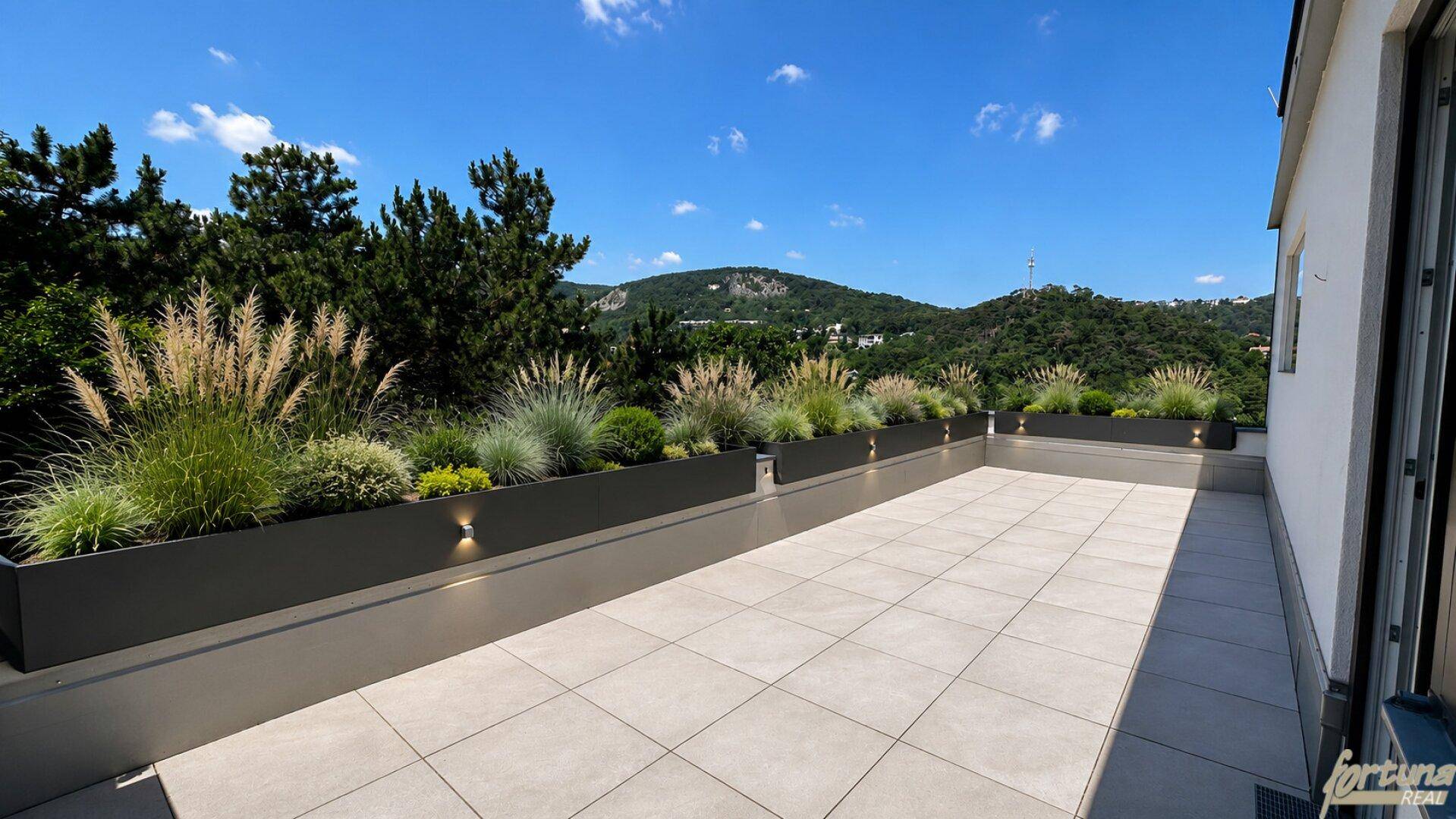 Helle, geflieste Terrasse mit modernen Pflanzgefäßen und weitem Blick auf die bewaldeten Hügel.