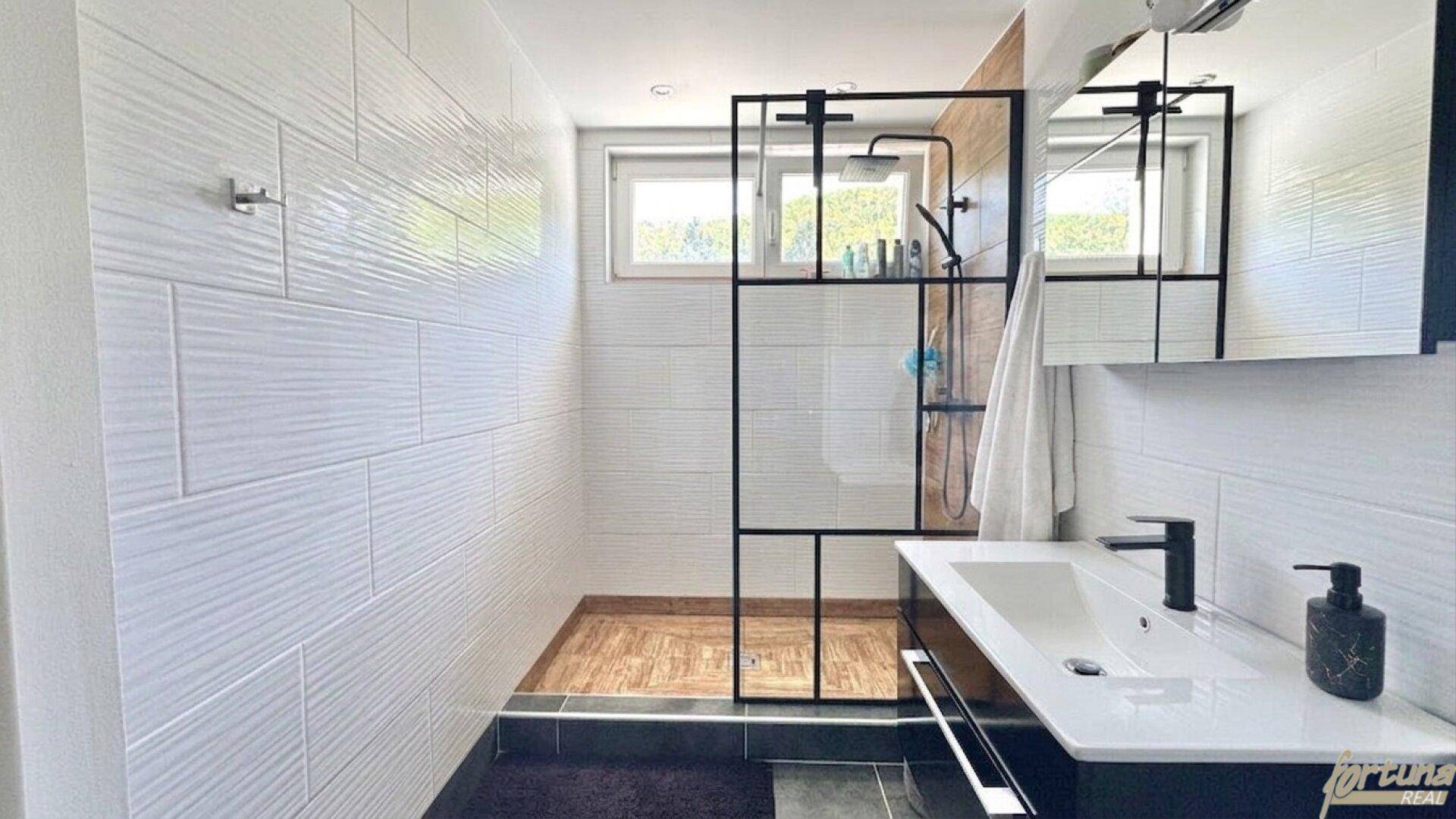 Modernes Badezimmer mit großer begehbarer Dusche und Fenster.