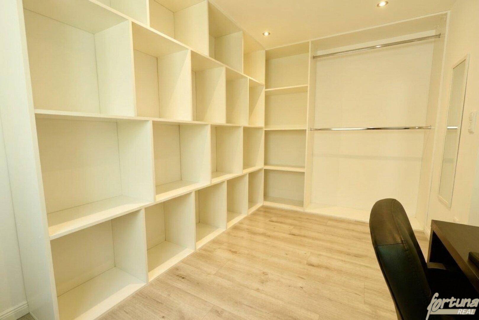Praktischer begehbarer Kleiderschrank mit vielen Regalen und Ablagemöglichkeiten.