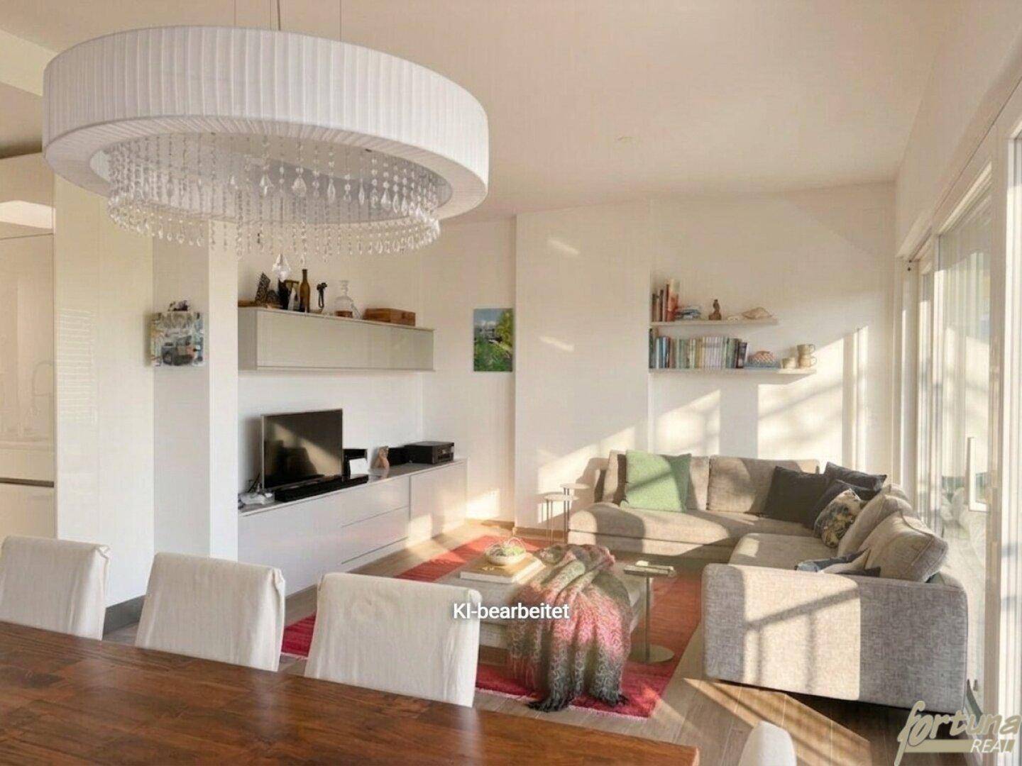 Heller Wohnbereich mit bequemer Couch, Holzboden und stilvoller Beleuchtung, offen zum Essbereich.