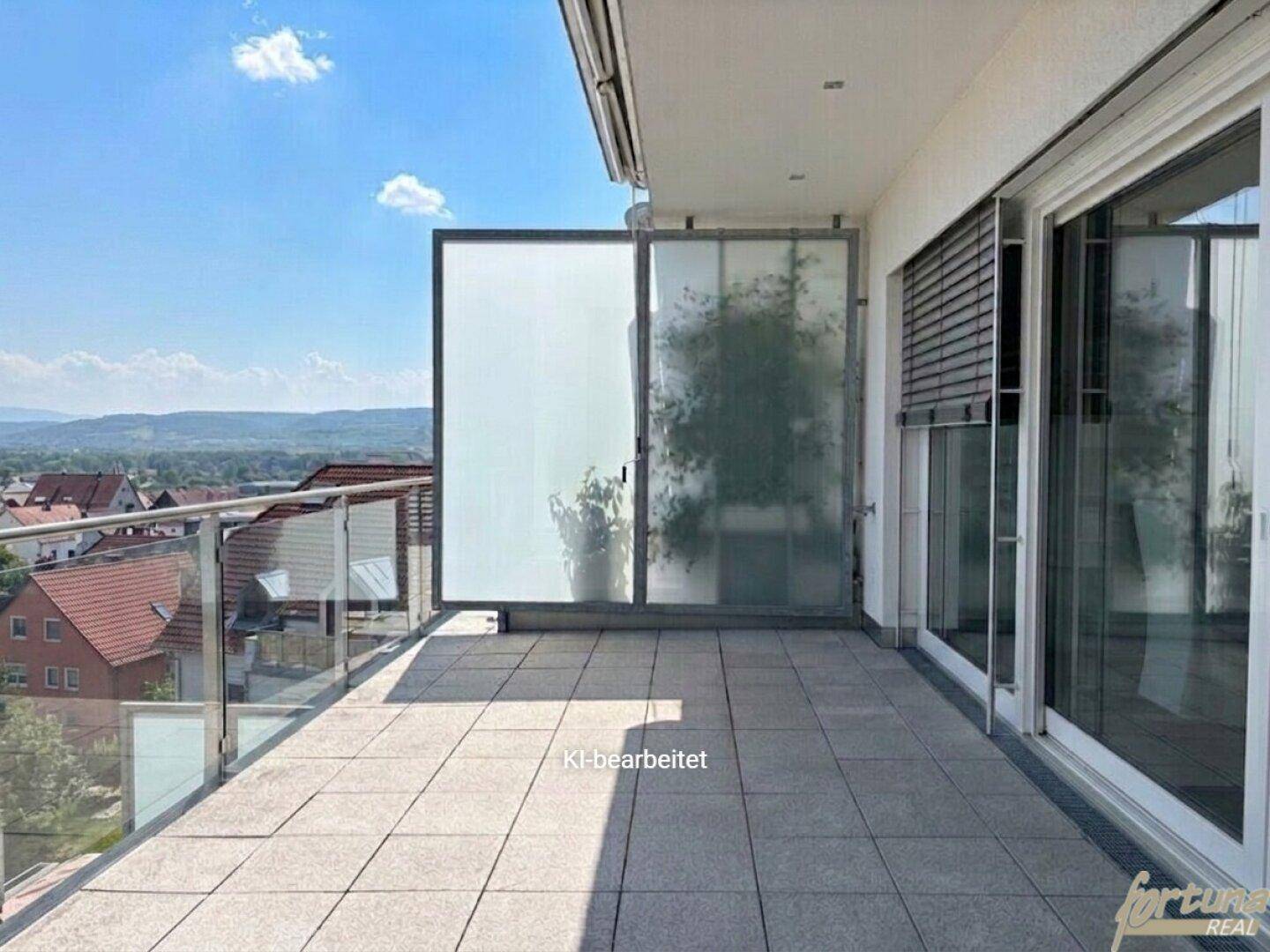 Geräumiger Balkon mit Fliesenboden und Glasgeländer, bietet einen weiten Blick über die Umgebung.
